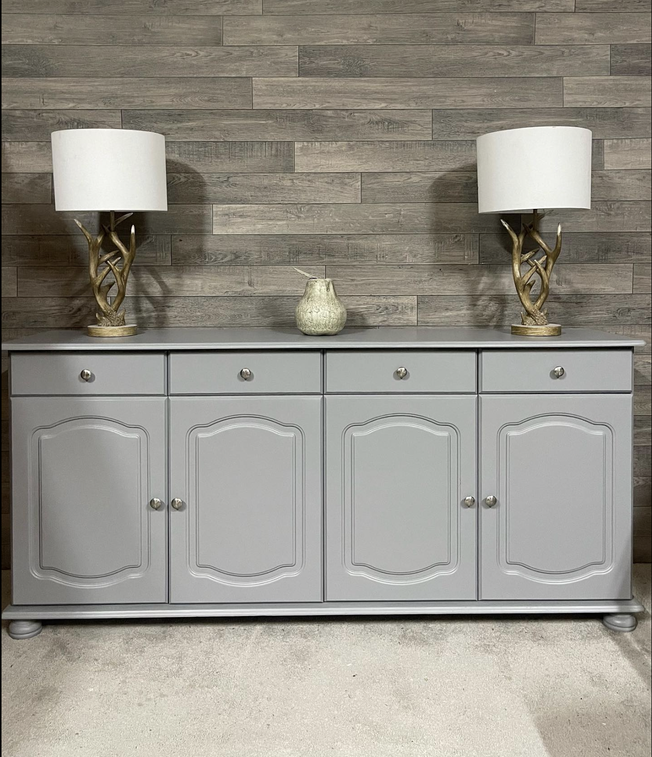 sustainable refurbished furniture example of a side board repainted in grey with two lamps placed upon it